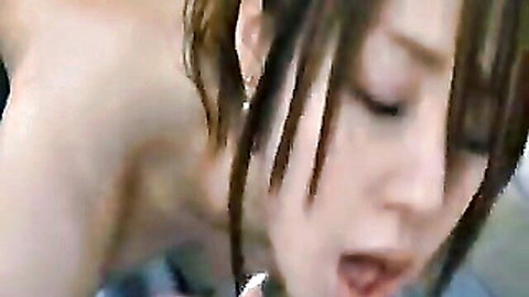 Closeup of young Japanese beauty with long hair and open mouth giving intense blowjob