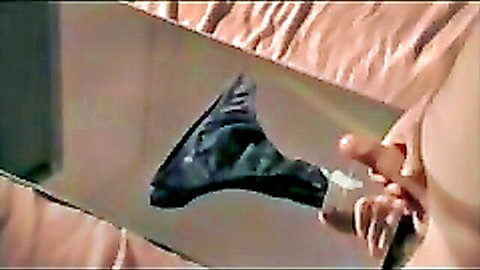 Woman teasing with cum-soaked black panties near exposed breast
