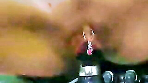 Tanned woman with clit piercing masturbating in car close-up