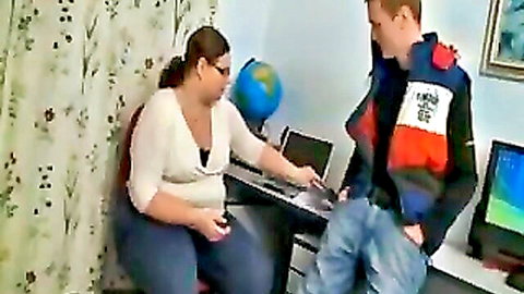 BBW teacher in white top chats with freckled student over laptop at desk