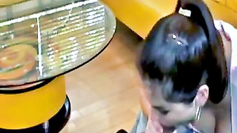 Brunette with ponytail kneels intently looking down ready for cock near yellow couch