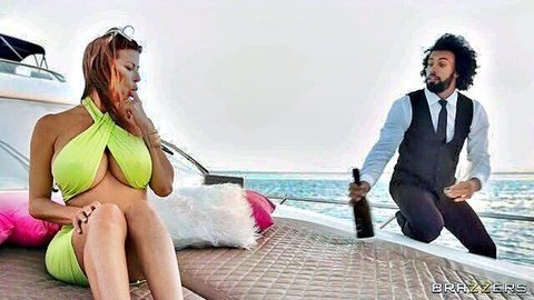 Alexis Fawx in sexy green halter dress on yacht, man serving wine at sea