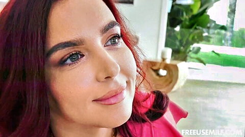 Sexy redhead with blue eyes and plump lips smiling seductively closeup
