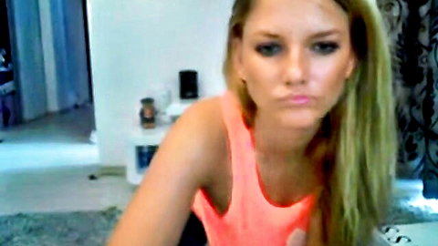 Sensual blonde babe with big tits and blue eyes pouting in tight pink tank top on amateur webcam