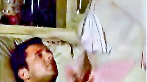 Brunette man lying shirtless on white sheets in grainy vintage bedroom after intense fuck