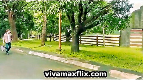Clothed Asian couple walks teasingly on lush green path outdoors