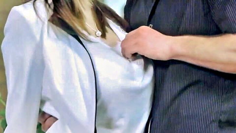 Man's hand groping busty woman's big tits through open white blazer