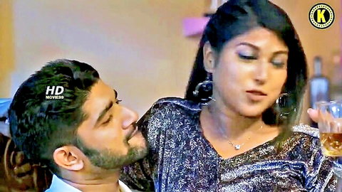 Sexy Indian babe with big tits in sparkly dress holds whiskey as stud kisses her neck intimately