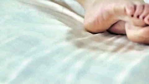 Romantic intimacy closeup of woman's legs and feet on bed