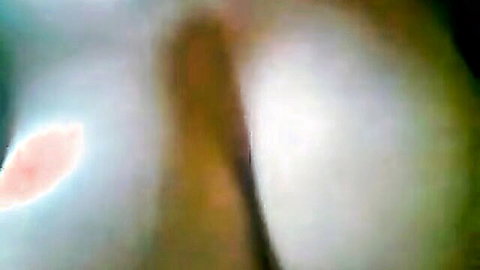 Busty woman with large breasts in blurry intimate scene, hinting at oral action
