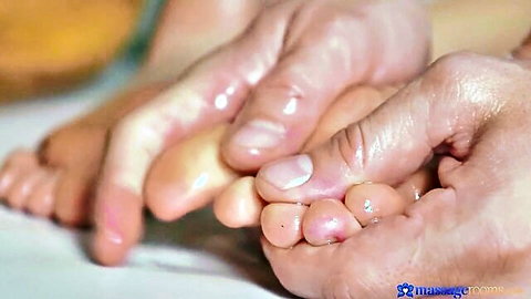 Man's strong hands massaging petite girl's small sexy feet in massage room