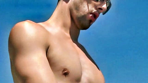 Muscular young hunk shirtless outdoors flexing ripped abs and nipples under sunglasses