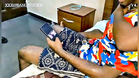 Muscular black stepbro in shorts watches steamy video on phone