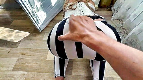 Blonde mature MILF in striped leggings bent over with hand grabbing her big ass