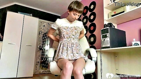 Amateur girl in floral dress stripping down in bedroom