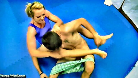 Blonde femdom wrestler in blue leotard pins nude guy exposing his cock on blue mats