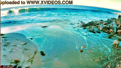Serene beach waves crashing on rocky shore with turquoise water at sunset