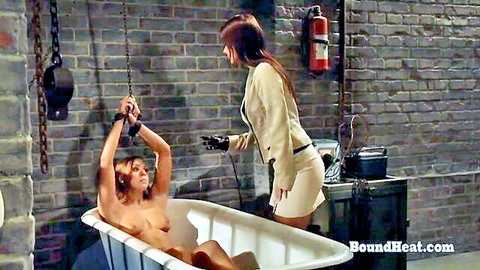Nude submissive lesbian bound in bathtub, shocked by dominant in BDSM electro therapy