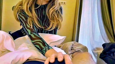 Blonde woman in sheer green top and pantyhose giving handjob lesson