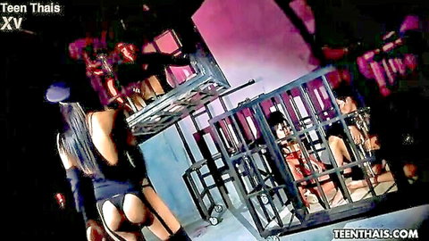Thai femdom mistress in latex police outfit bends over cage with hairy naked sub inside