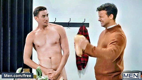 Muscular naked guy covers his cock with hands and towel as smiling clothed stud holds sneaker in locker room