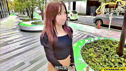 Asian woman with long red hair walks outdoors in black crop top and skirt, masked and stylish