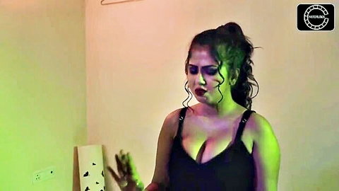 Seductive curvy Indian woman in low-cut black dress showing deep cleavage