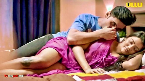 Indian couple in passionate embrace, man kissing woman's neck in pink dress