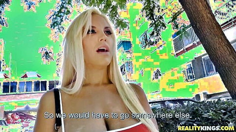 Busty blonde with huge tits in low-cut red top teasing outdoors