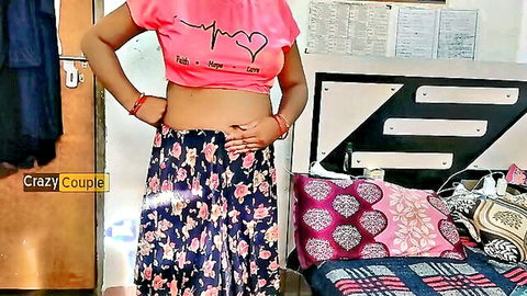 Sexy Indian woman in tight pink crop top and floral skirt posing with bare midriff