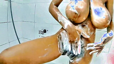Ebony babe with big soapy tits spreads suds on wet pussy in shower