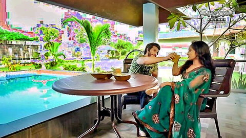 Indian woman in green saree fed drink by man in romantic couple scene