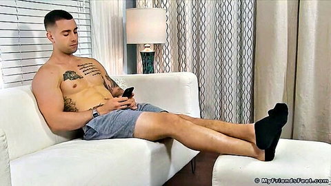 Handsome KC lounges shirtless, muscular tattoos, teasing feet in black socks