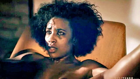 Topless ebony babe with huge curly afro hair and medium tits leans back moaning intensely on chair