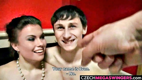 Smiling Czech swinger couple in apartment with extended hand gesture from Czech Mega Swingers
