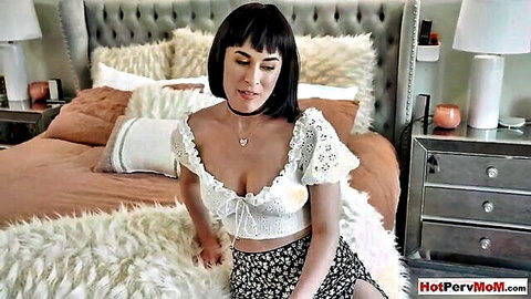 Olive Glass MILF in white off-shoulder top and floral skirt seducing on bed