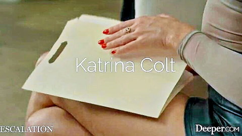 Katrina Colt in beige top and green skirt holding folder, Deeper Bound Vol 3
