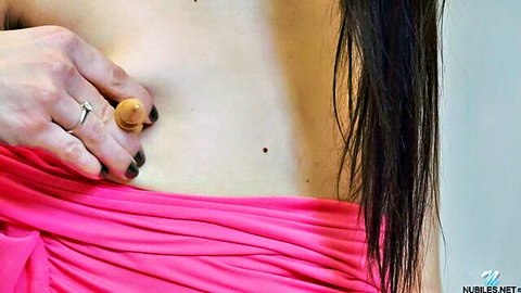 Brunette with long hair presses small flesh dildo against fair smooth stomach above pink panties