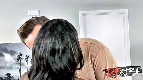 White man passionately kisses nude ebony woman's neck from behind in intimate interracial embrace