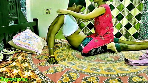 Young Indian girl in red top caresses muscular guy's bare abs on floor in homemade tease