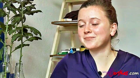 Smiling brunette MILF in purple scrubs seduces with playful eyes closed expression