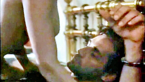 Brunette woman nude straddling handcuffed man in dominant sex scene