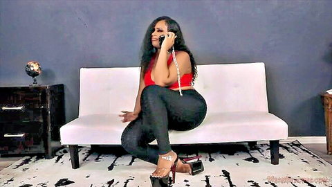 Sexy ebony babe in red halter top and tight black pants seductively talks on phone showing deep cleavage and curves