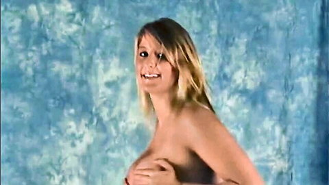 Smiling blonde babe topless covering perky tits with hands in sensual tease