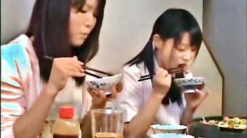 Cute Asian sisters sharing noodles, innocent teen schoolgirl moment