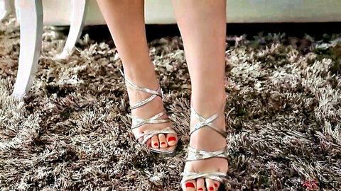 Angela White's toned legs in sexy silver strappy high heels with red toenails