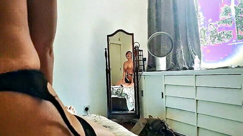 British MILF in black thong spreads legs on bed with nude man reflected in mirror