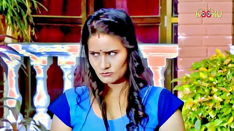 Seductive Indian woman in blue top pouting sensually outdoors with cleavage tease