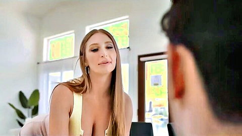 Busty blonde in yellow tank top with deep cleavage leans toward shirtless guy