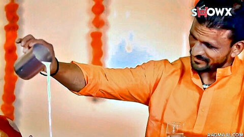 Indian man in saffron kurta pouring white liquid into glass
